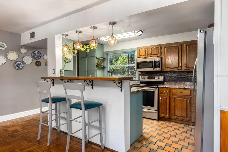 Fresh paint, updated pendant lights, reupholstered and painted barstools, stone tile backsplash, and updated countertops.
